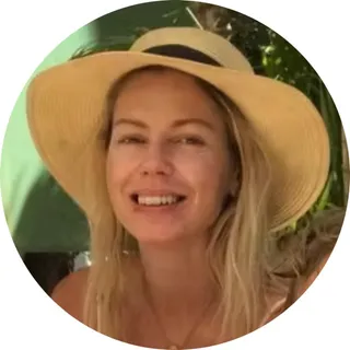 Maria Kusk, Steward of Social Media, smiling in a straw sunhat outdoors.