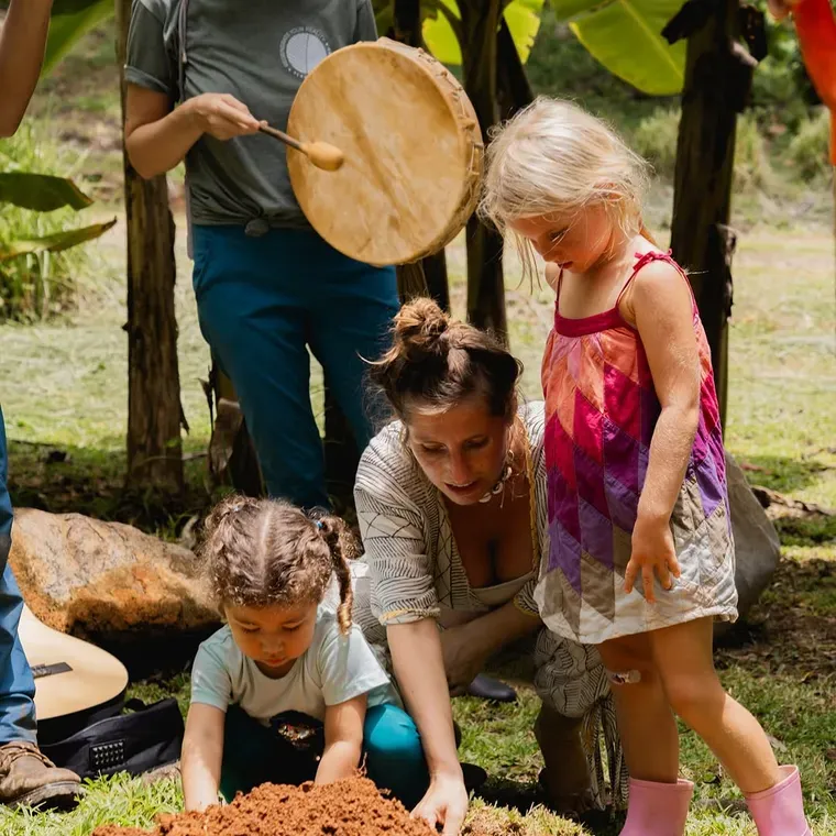Children planting with a drum sounding beside them